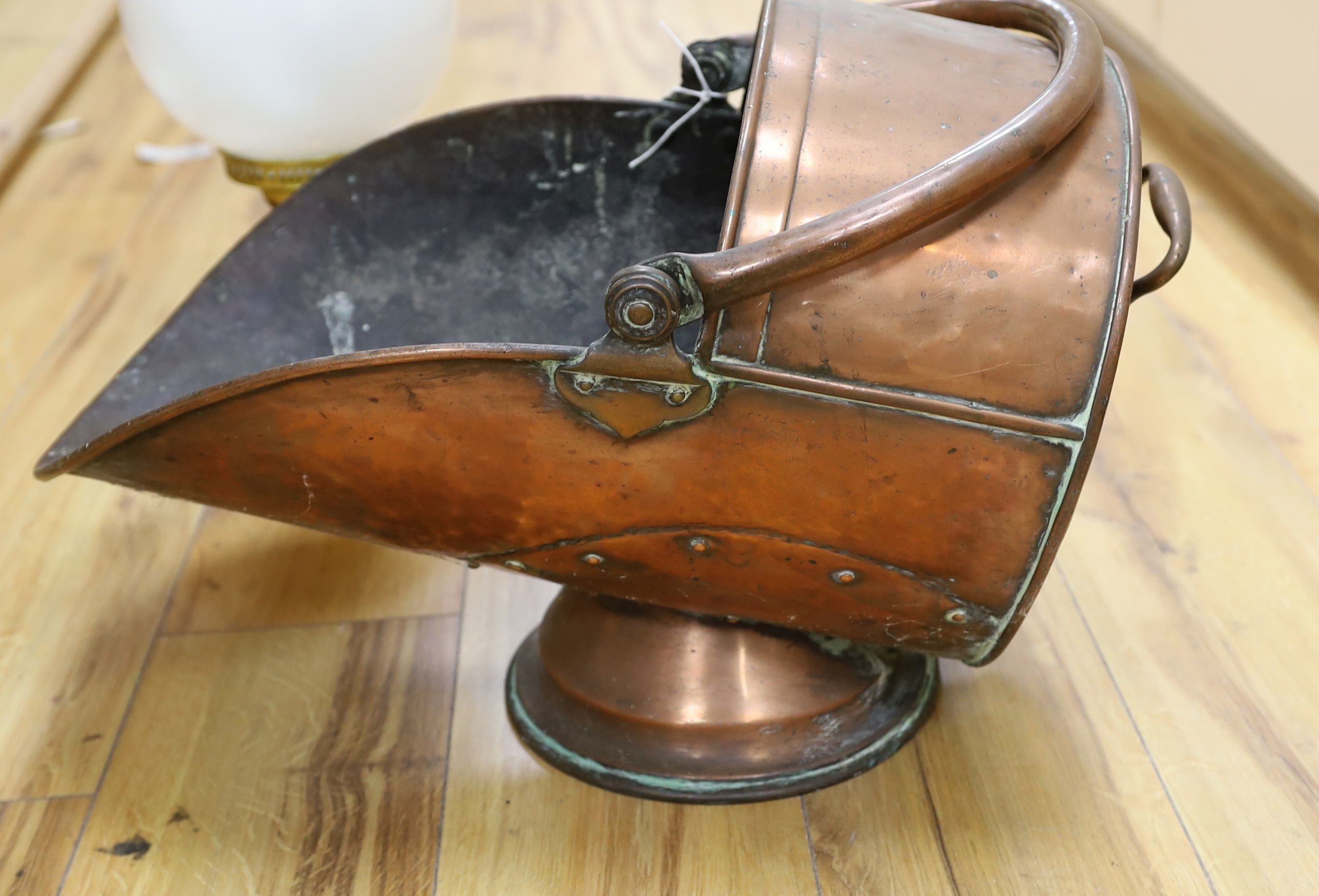 A Victorian copper coal scuttle and a lamp